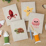 The four finished Smiling Sea Friends mini canvases laid out on a table