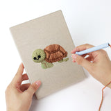 Punching a Smiling Sea Friends mini canvas with the punch needle