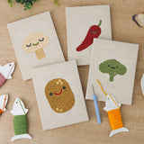 The four finished Smiling Veggies mini canvases laid out on a table