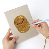 Punching a Smiling Veggies mini canvas with the punch needle
