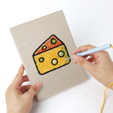 Punching a Snack Time Treats mini canvas with the punch needle
