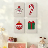 The four Snowman and Bauble mini canvases on a wall above a shelf
