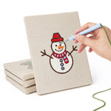 Hand punching one of the Snowman and Bauble mini canvases