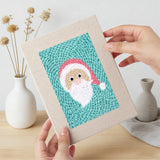 Hand holding a finished Snowman and Wreath mini canvas