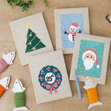 The four finished Snowman and Wreath mini canvases laid out on a table