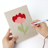 Punching a Soft Tulip Stems mini canvas with the punch needle