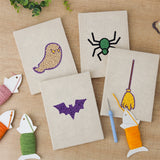 The four finished Spider and Broom mini canvases laid out on a table