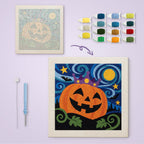 Starry Pumpkin King canvas before and after punching, with the threads and tools