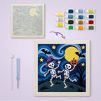 Starry Skeleton Duo canvas before and after punching, with the threads and tools