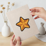 Hand holding a finished Stocking and Star mini canvas