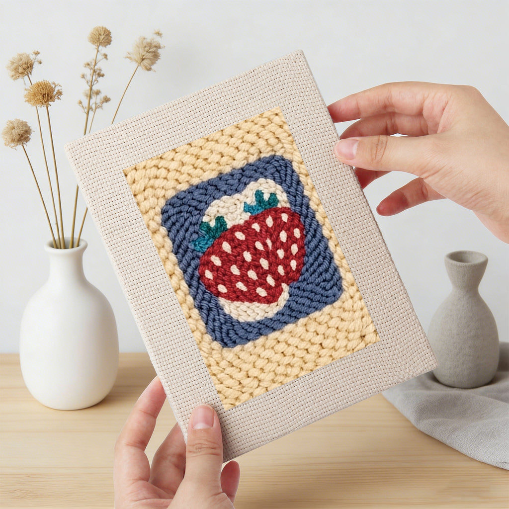 Hand holding a finished Strawberry and Bananas mini canvas