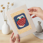 Hand holding a finished Strawberry and Bananas mini canvas
