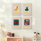 The four Strawberry and Bananas mini canvases on a wall above a shelf