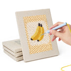 Hand punching one of the Strawberry and Bananas mini canvases