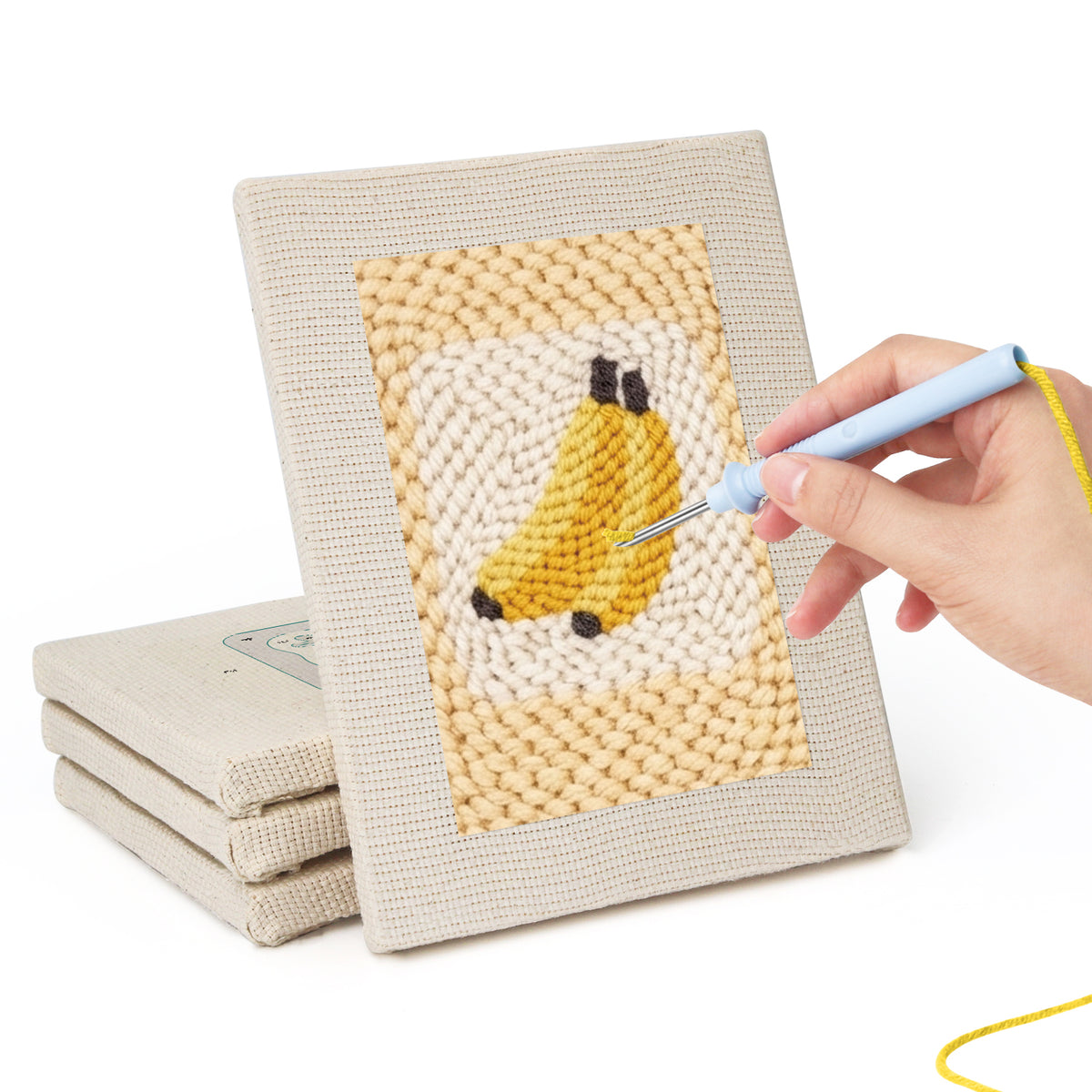 Hand punching one of the Strawberry and Bananas mini canvases