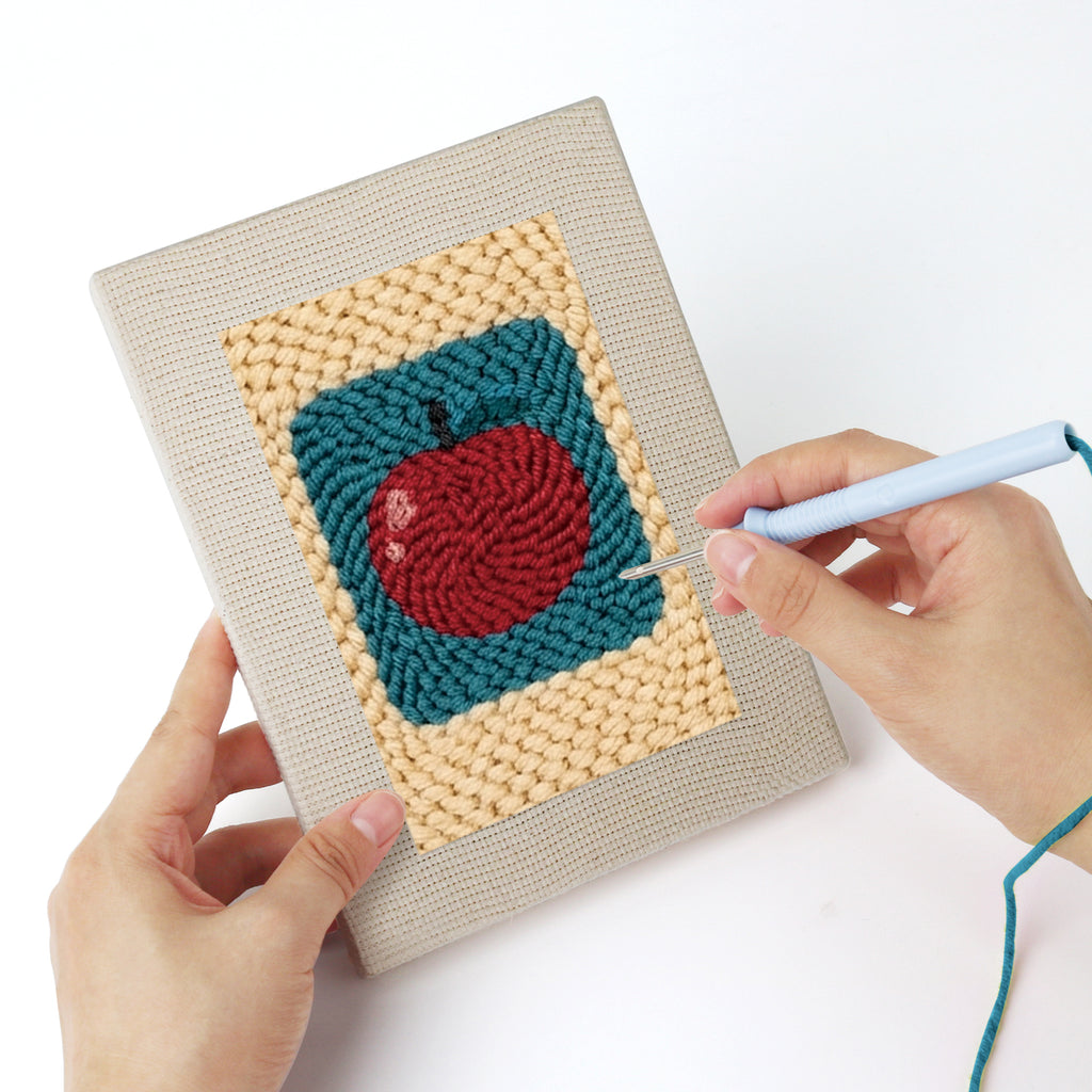 Punching a Strawberry and Bananas mini canvas with the punch needle