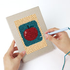 Punching a Strawberry and Bananas mini canvas with the punch needle