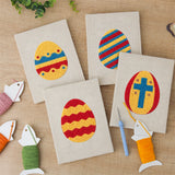 The four finished Striped Easter Eggs mini canvases laid out on a table