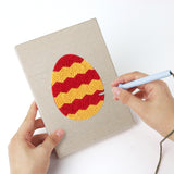 Punching a Striped Easter Eggs mini canvas with the punch needle