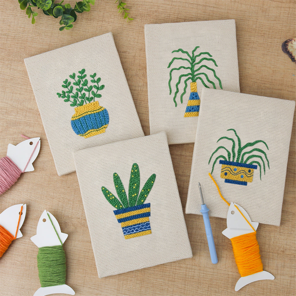 The four finished Striped Pot Plants mini canvases laid out on a table