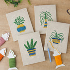 The four finished Striped Pot Plants mini canvases laid out on a table