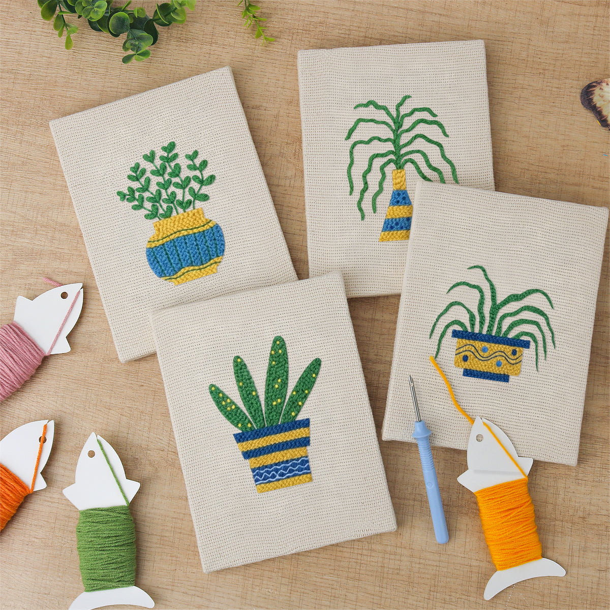 The four finished Striped Pot Plants mini canvases laid out on a table