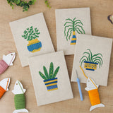 The four finished Striped Pot Plants mini canvases laid out on a table