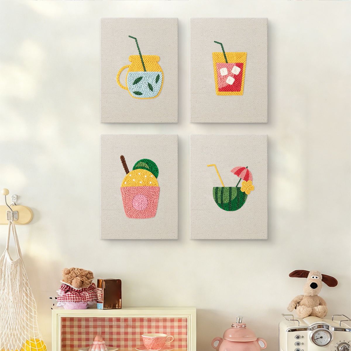 The four Summer Sips mini canvases on a wall above a shelf