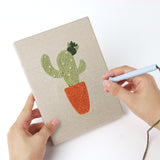Punching a Sunny Pot Houseplants mini canvas with the punch needle