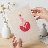 Hand holding a finished Sweetheart Charms mini canvas