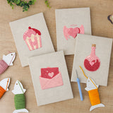 The four finished Sweetheart Charms mini canvases laid out on a table