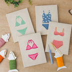 The four finished Swimsuit Season mini canvases laid out on a table