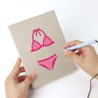 Punching a Swimsuit Season mini canvas with the punch needle
