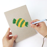 Punching a Swirl Lollipops mini canvas with the punch needle