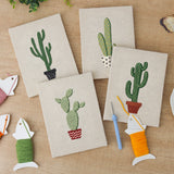 The four finished Tall Potted Cacti mini canvases laid out on a table