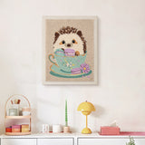Finished Teacup Hedgehog punch needle canvas on a wall
