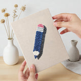 Hand holding a finished Teal Alarm Clock mini canvas