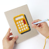 Punching a Teal Alarm Clock mini canvas with the punch needle