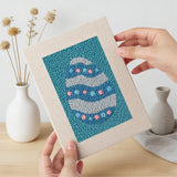 Hand holding a finished Teal Easter Eggs mini canvas