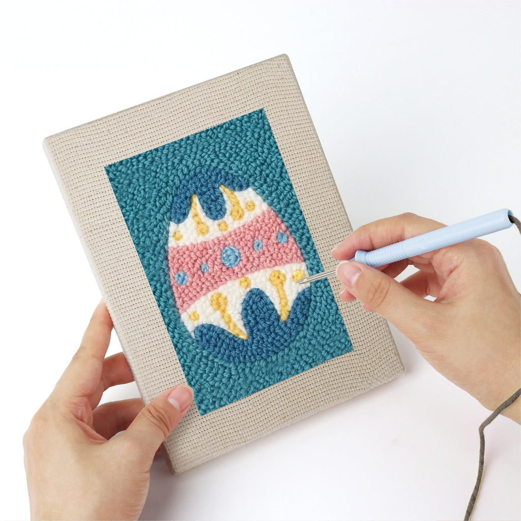 Punching a Teal Easter Eggs mini canvas with the punch needle
