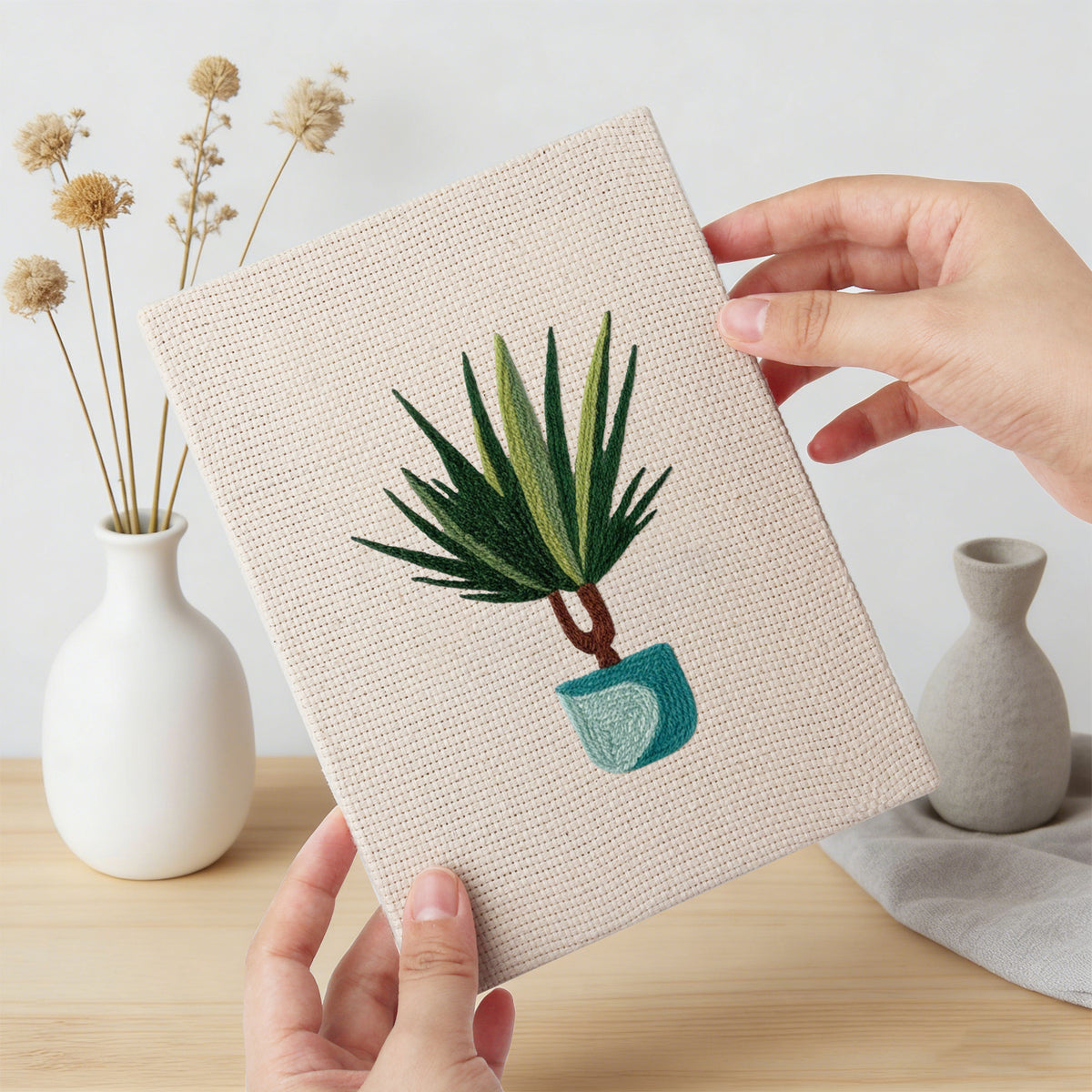 Hand holding a finished Teal Pot Greens mini canvas