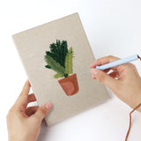 Punching a Teal Pot Greens mini canvas with the punch needle