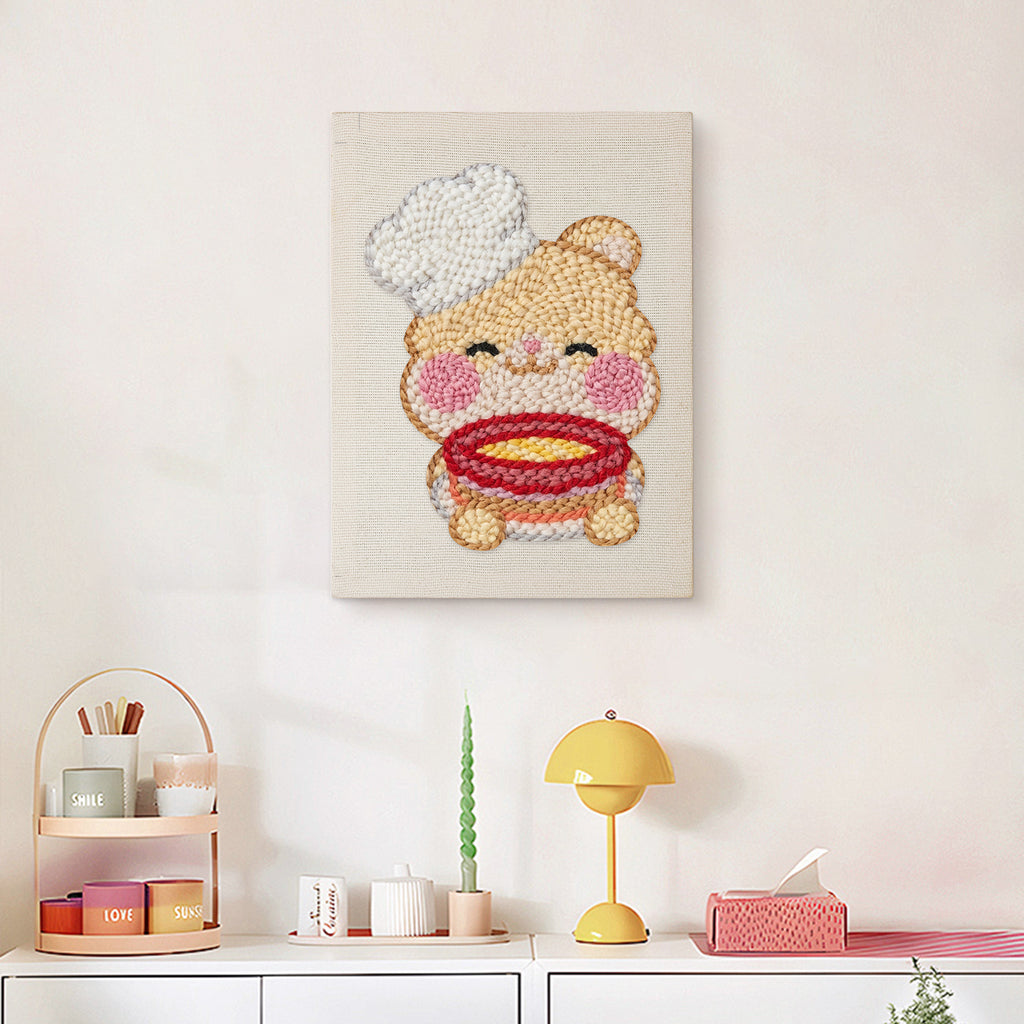 Finished Teddy Bear Chef punch needle canvas on a wall