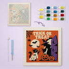 Trick or Treat Doorstep canvas before and after punching, with the threads and tools