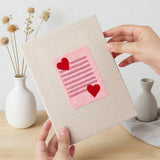 Hand holding a finished Valentine Notes mini canvas