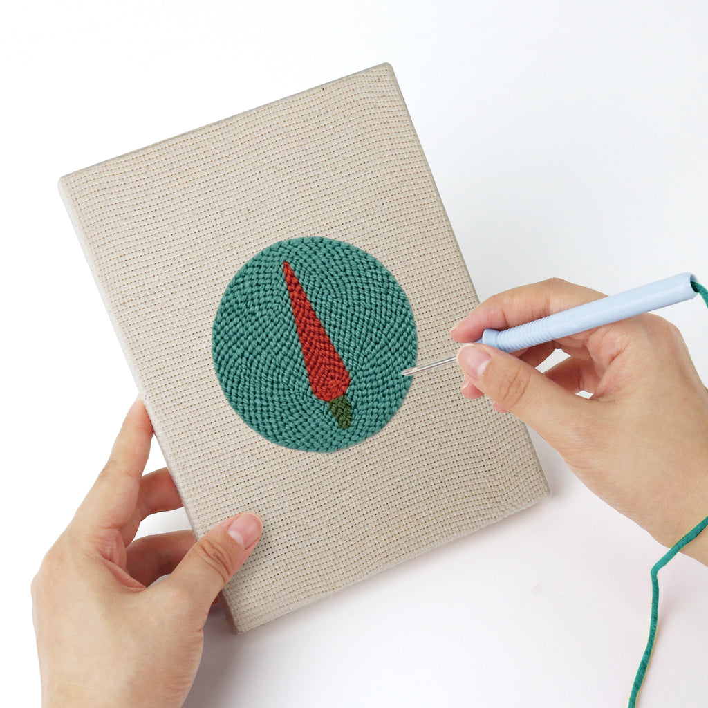 Punching a Veggie Circles mini canvas with the punch needle