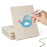 Hand punching one of the Watering Can Apples mini canvases