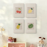 The four Watermelon and Lemon mini canvases on a wall above a shelf