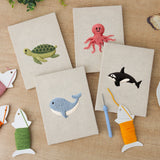 The four finished Whale and Orca mini canvases laid out on a table