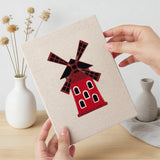 Hand holding a finished Windmill Village mini canvas